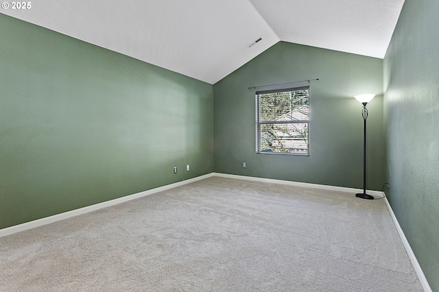 carpeted spare room featuring lofted ceiling