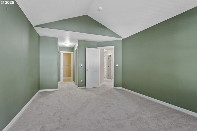 unfurnished bedroom with light colored carpet and vaulted ceiling