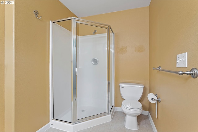 bathroom featuring tile patterned flooring, toilet, and walk in shower