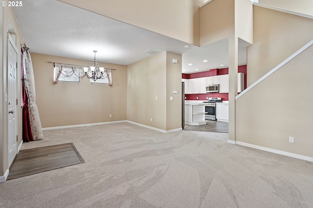 unfurnished dining area featuring a textured ceiling, light carpet, and a notable chandelier