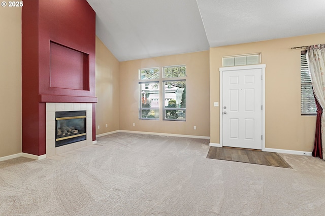 entryway featuring a fireplace, vaulted ceiling, and carpet