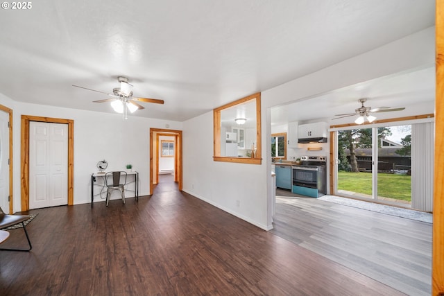 unfurnished living room featuring a ceiling fan, wood finished floors, and baseboards