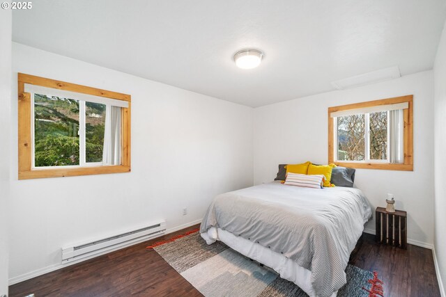 bedroom with wood finished floors, attic access, baseboards, and a baseboard radiator