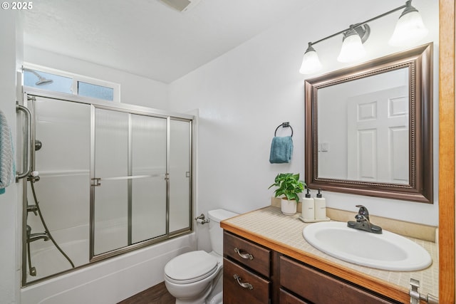 full bathroom with vanity, toilet, and bath / shower combo with glass door