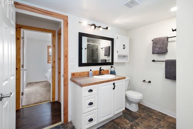 full bathroom with visible vents, baseboards, toilet, a stall shower, and vanity