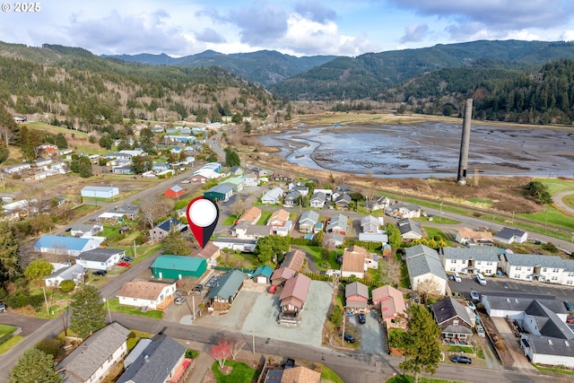 birds eye view of property featuring a mountain view, a residential view, and a wooded view