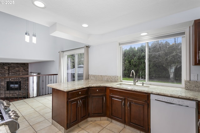 7134 SW 184th Pl, Beaverton, OR 97007 - kitchen featuring dishwasher, light tile patterned floors, a fireplace, light stone countertops, and recessed lighting