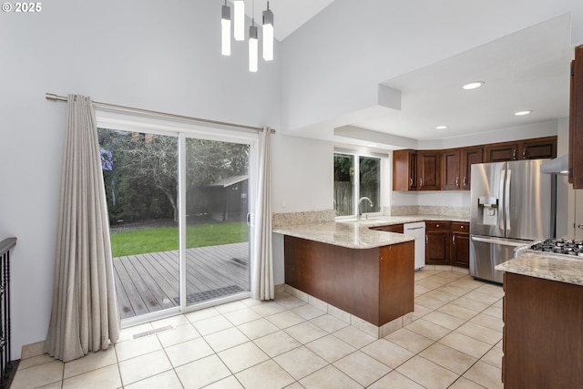 7134 SW 184th Pl, Beaverton, OR 97007 - kitchen with stainless steel refrigerator with ice dispenser, a peninsula, high vaulted ceiling, light tile patterned floors, and light stone counters