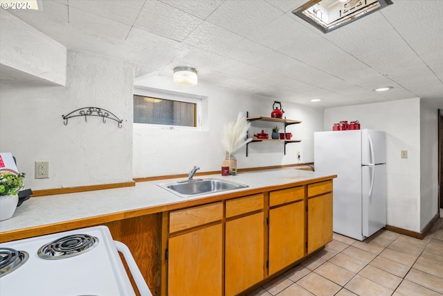 kitchen featuring white appliances, a sink, light countertops, open shelves, and light tile patterned floors