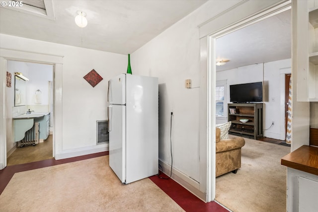 kitchen with freestanding refrigerator, baseboards, and carpet