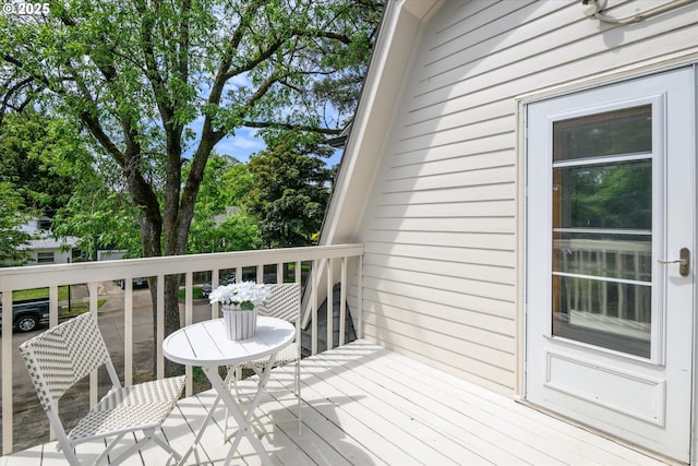 wooden terrace featuring view of wooded area