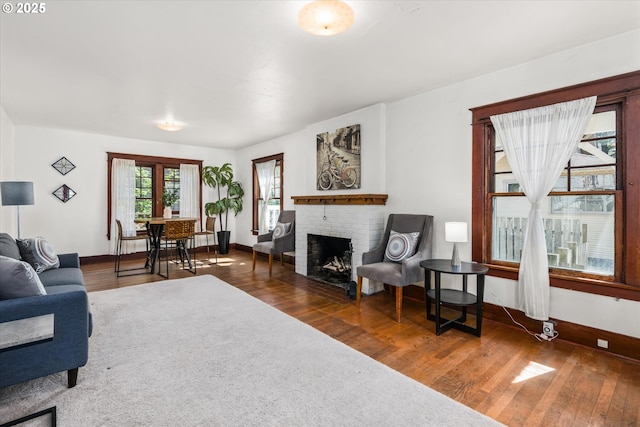 living room with wood finished floors, baseboards, and a fireplace
