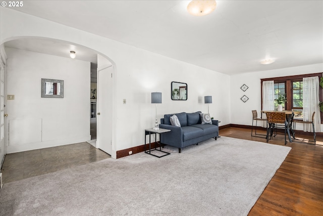 living area with arched walkways and baseboards