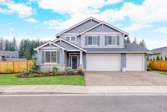 craftsman house with a front lawn, a garage, fence, and board and batten siding