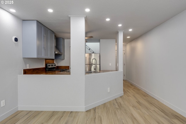 kitchen featuring light wood finished floors, recessed lighting, stainless steel appliances, and baseboards