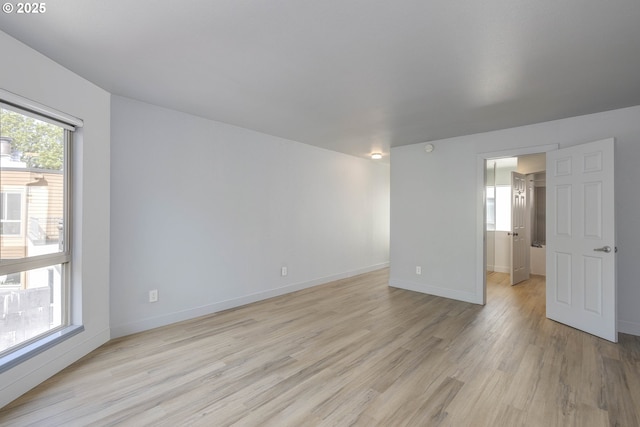 interior space featuring baseboards and light wood finished floors