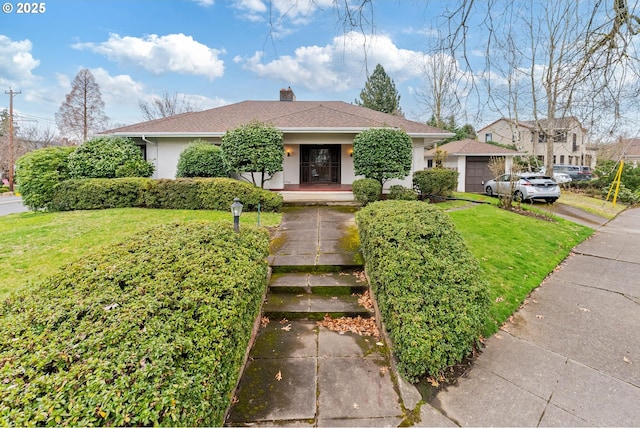 view of front facade with a front yard, covered porch, stucco siding, a chimney, and a garage