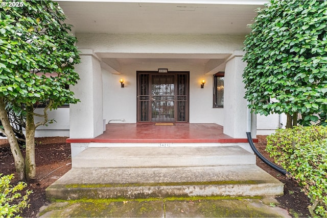 property entrance featuring stucco siding and a porch