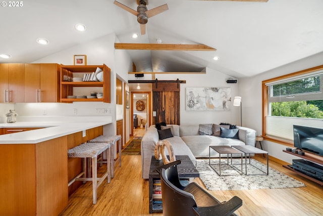 living room featuring ceiling fan, a barn door, recessed lighting, light wood-type flooring, and vaulted ceiling