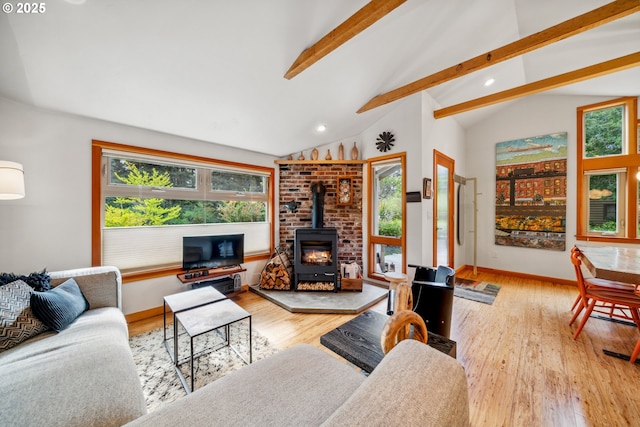 living area with lofted ceiling with beams, a wood stove, recessed lighting, baseboards, and wood finished floors