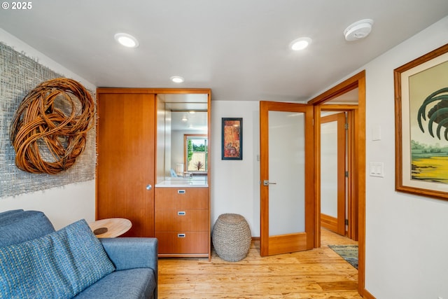 living area with light wood-style floors, baseboards, and recessed lighting