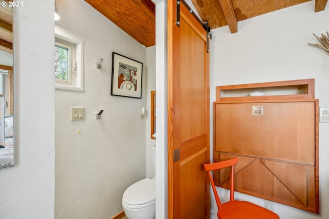 bathroom featuring toilet and beamed ceiling