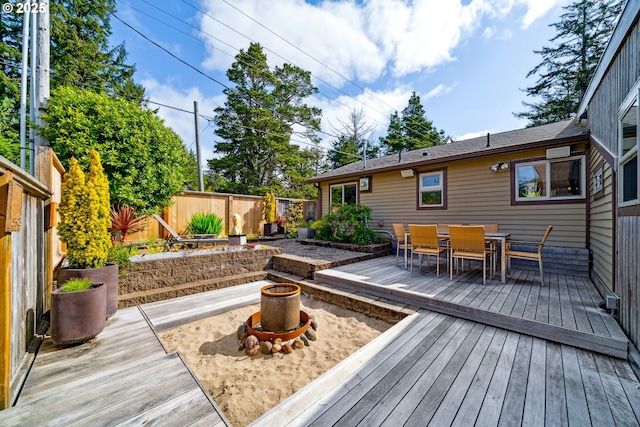 wooden terrace featuring outdoor dining area and a fenced backyard