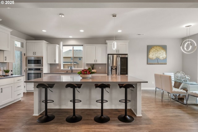 17085 SE Troge Rd, Happy Valley, OR 97086 - kitchen featuring appliances with stainless steel finishes, plenty of natural light, decorative backsplash, a kitchen island, and recessed lighting