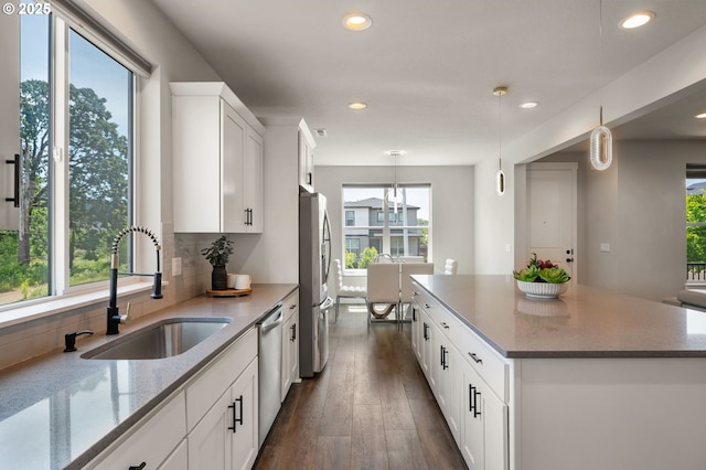 17085 SE Troge Rd, Happy Valley, OR 97086 - kitchen with healthy amount of natural light, stainless steel appliances, light stone countertops, recessed lighting, and dark wood-style flooring