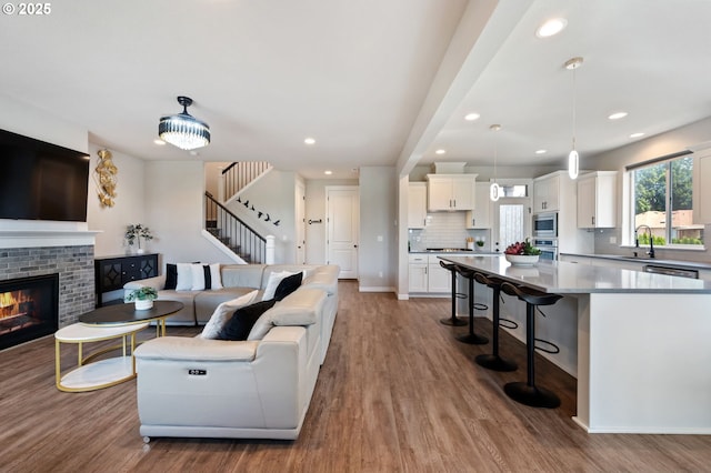 17085 SE Troge Rd, Happy Valley, OR 97086 - living room featuring wood finished floors, stairway, recessed lighting, and a brick fireplace