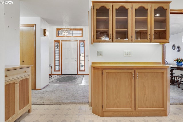 kitchen with a chandelier, light carpet, and light brown cabinets