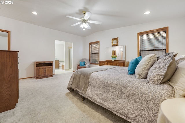 bedroom with lofted ceiling, light colored carpet, ceiling fan, and ensuite bath