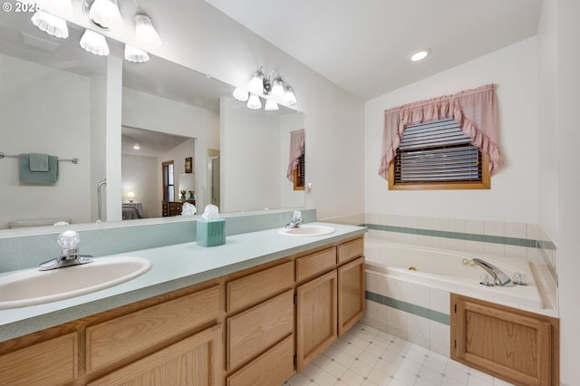 bathroom featuring a relaxing tiled tub, vanity, and vaulted ceiling