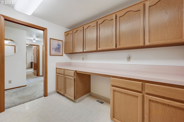 kitchen with built in desk and light brown cabinets