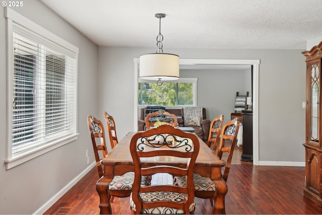 dining area featuring dark wood-style flooring and baseboards