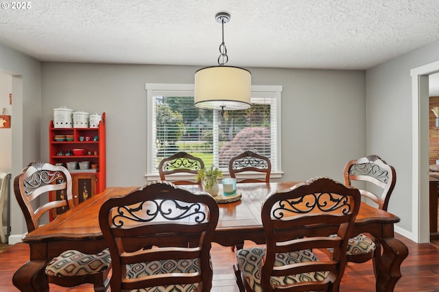 dining space featuring wood finished floors and a textured ceiling