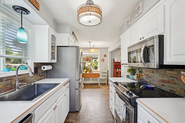 kitchen featuring stainless steel appliances, a sink, tasteful backsplash, white cabinets, and glass insert cabinets