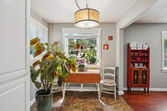 living area featuring a textured ceiling and baseboards