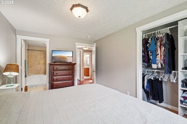 bedroom with a closet, a textured ceiling, and ensuite bath