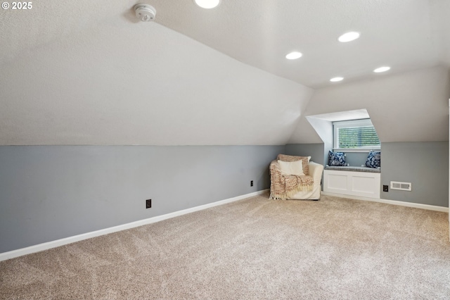 unfurnished room featuring lofted ceiling, light colored carpet, baseboards, and recessed lighting