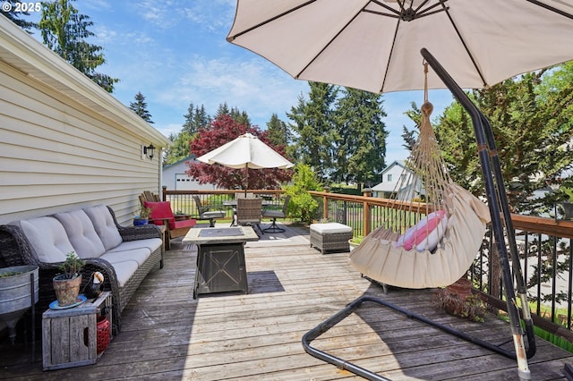 deck featuring an outdoor living space with a fire pit