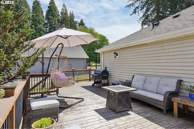 wooden deck featuring grilling area and an outdoor living space with a fire pit
