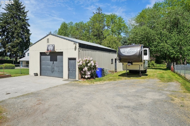 detached garage with fence and driveway