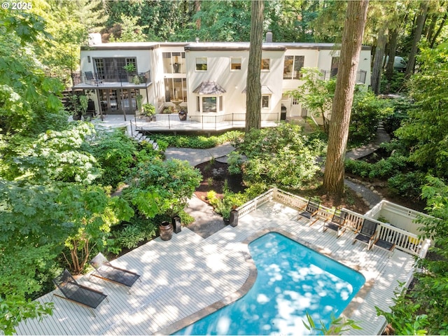 2917 Westview Cir, Lake Oswego, OR 97034 - back of house with a chimney, stucco siding, an outdoor pool, a patio area, and view of scattered trees