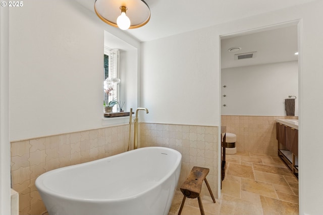 2917 Westview Cir, Lake Oswego, OR 97034 - bathroom with tile walls, a wainscoted wall, vanity, a freestanding bath, and stone tile floors