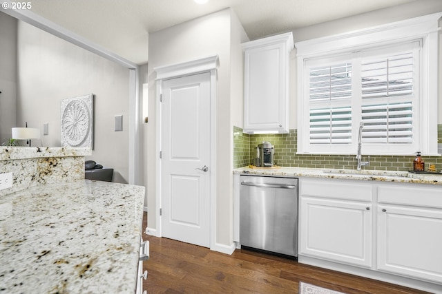 kitchen featuring white cabinets, dark wood-style floors, backsplash, stainless steel dishwasher, and a sink