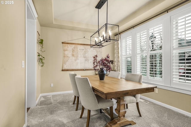 dining room with visible vents, baseboards, a raised ceiling, carpet floors, and a chandelier