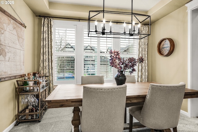 dining room with a notable chandelier and baseboards