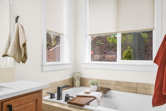 full bathroom featuring a garden tub and vanity