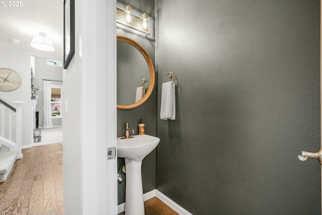 bathroom with a sink, baseboards, and wood finished floors